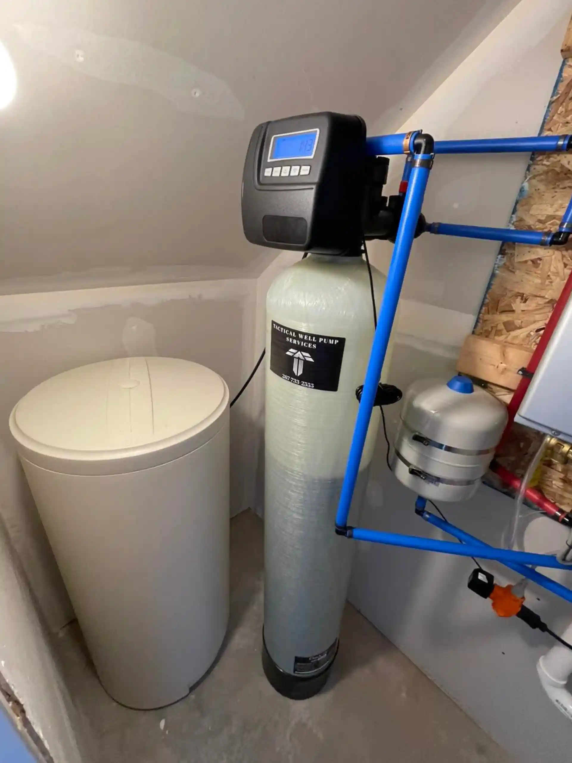 Experienced technician testing well water treatment components and checking system flow settings