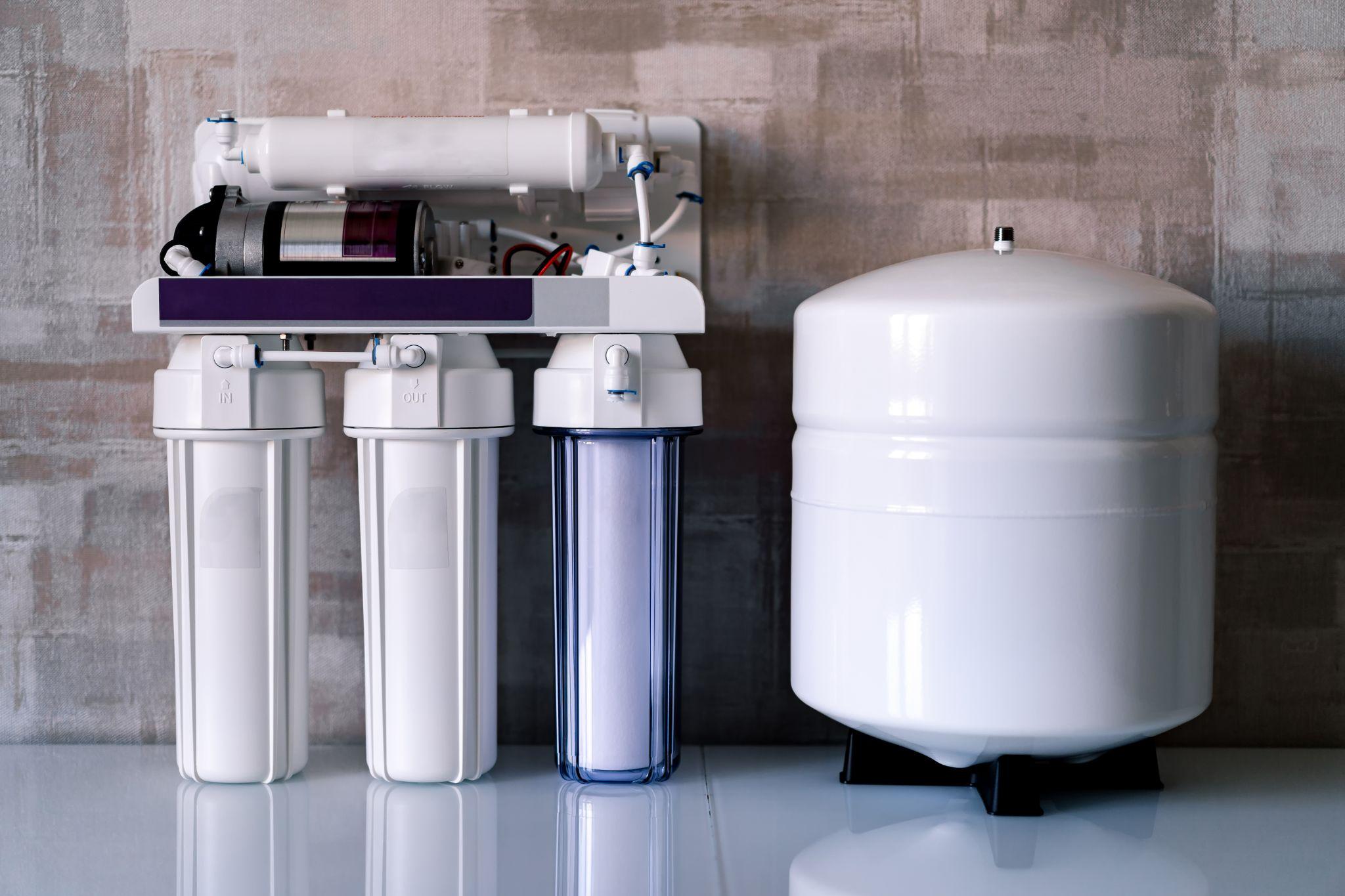 Skilled technician connecting reverse osmosis filters and dedicated faucet with precision tools
